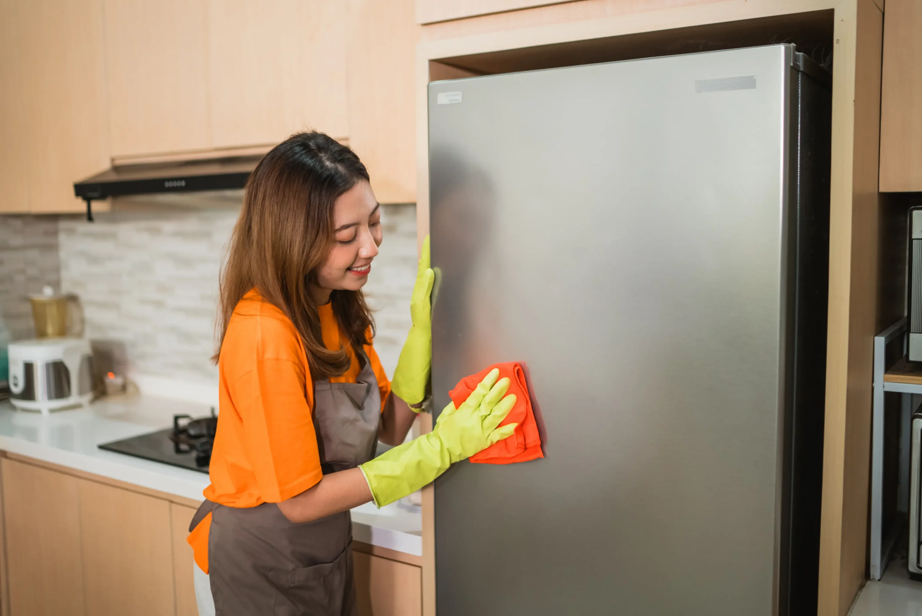 A imagem atual não possui texto alternativo. O nome do arquivo é: asian-woman-wipes-refrigerator-using-rag-kitchen.webp