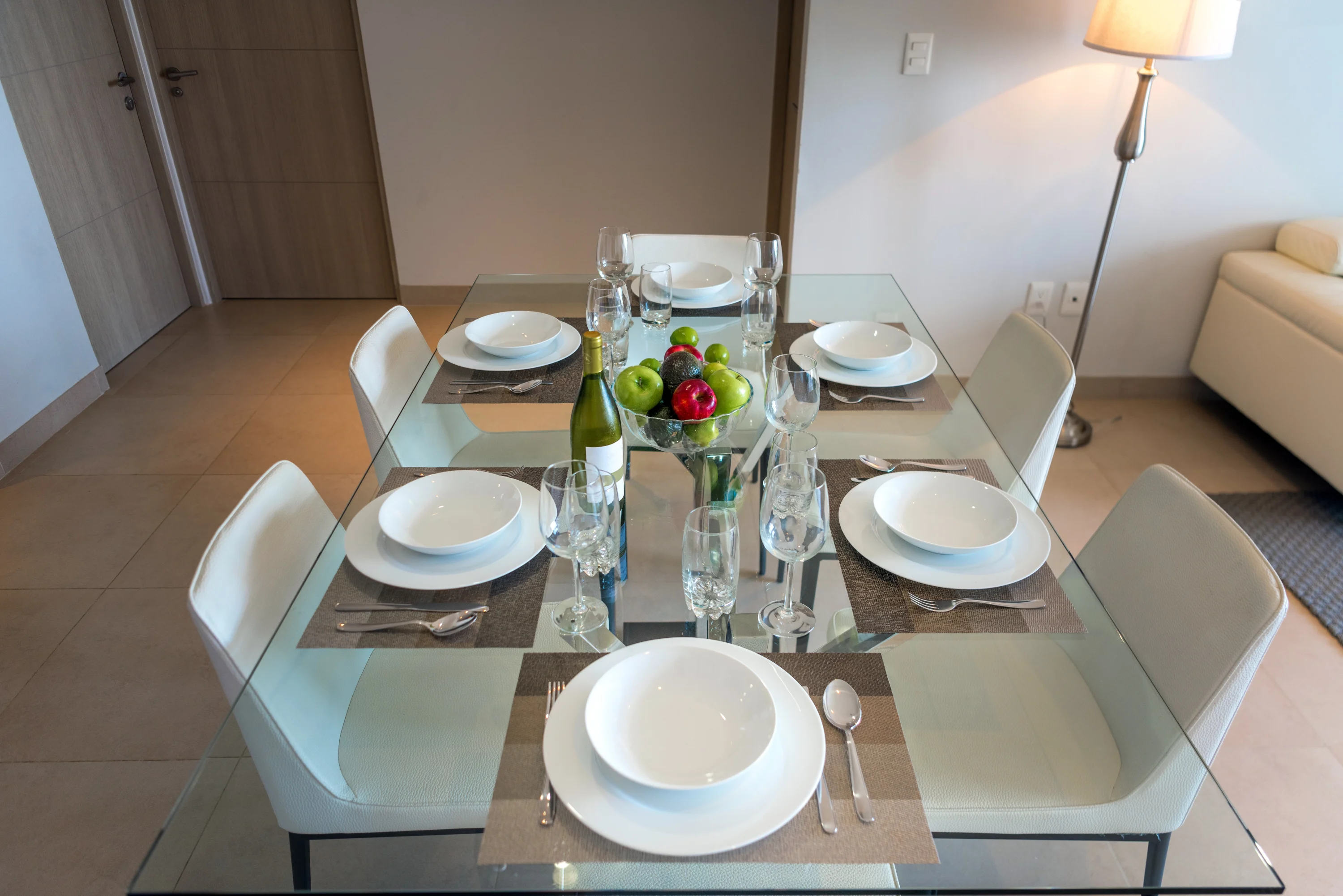 Imagem de mesa de jantar montada com seis lugares, para ilustrar qual é a posição dos talheres na mesa simples