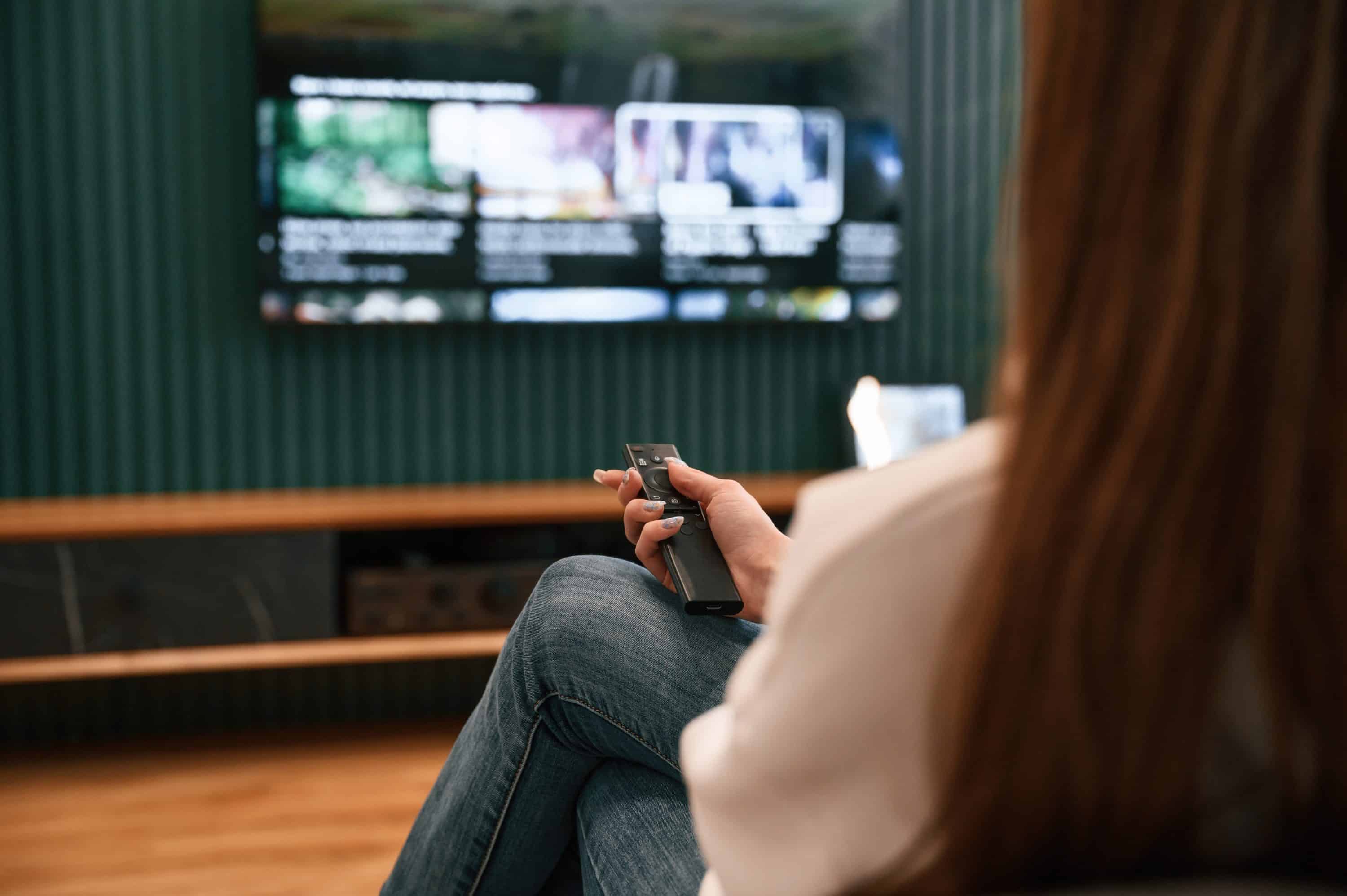 mulher escolhendo qual a melhor marca de televisão