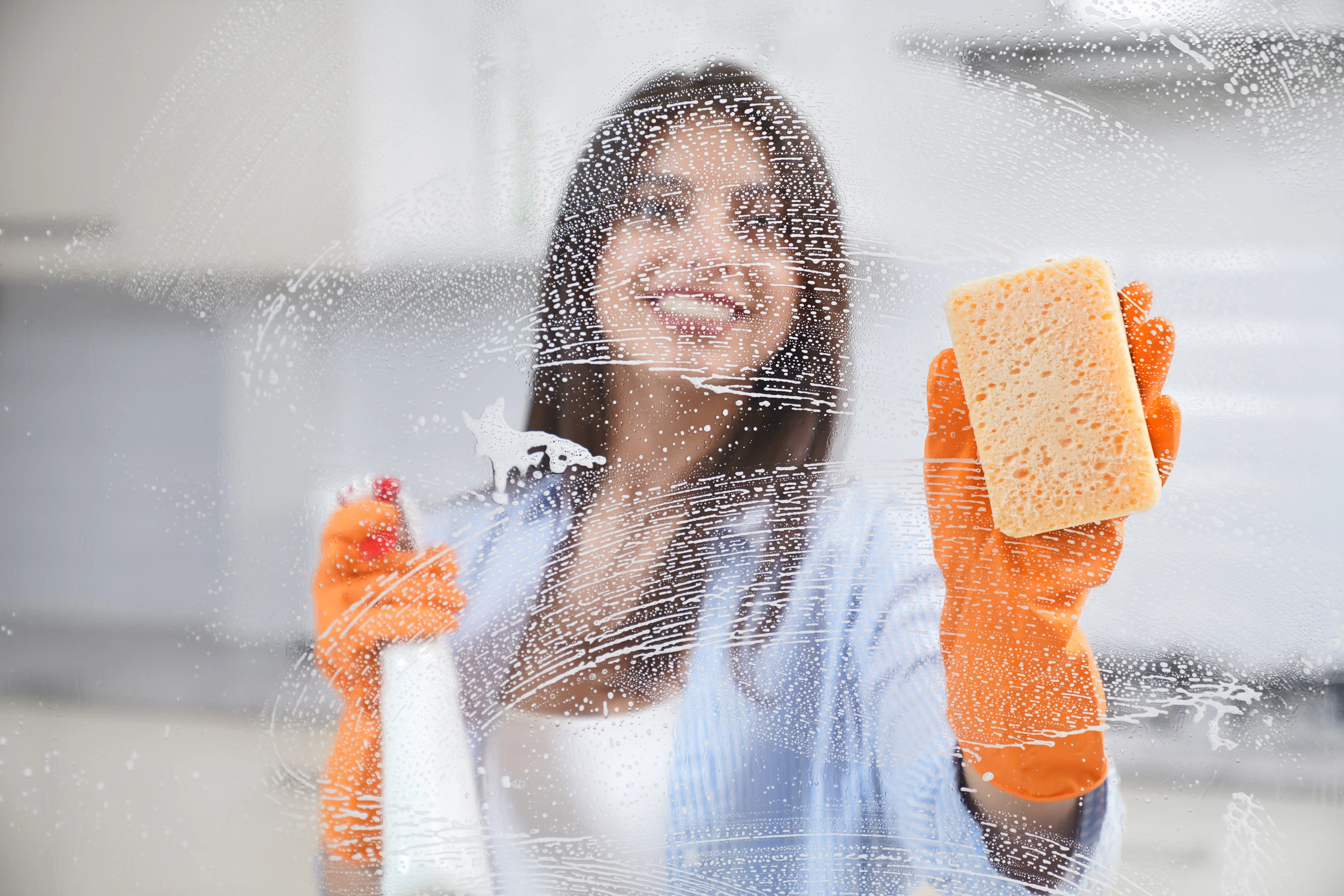 mulher aplicando dicas de como limpar vidro