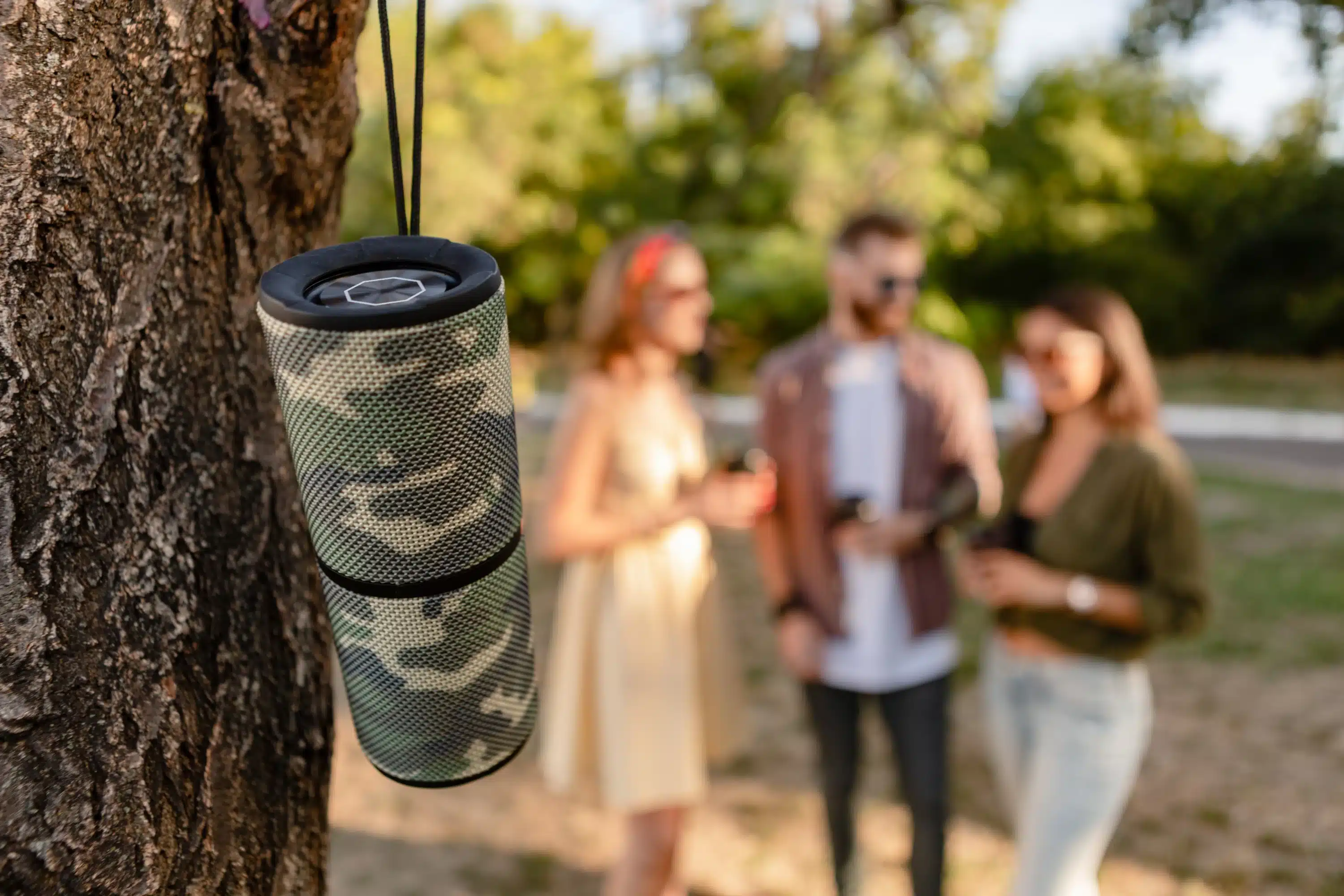 Amigos no parque ouvindo música em caixa de som bluetooth portátil